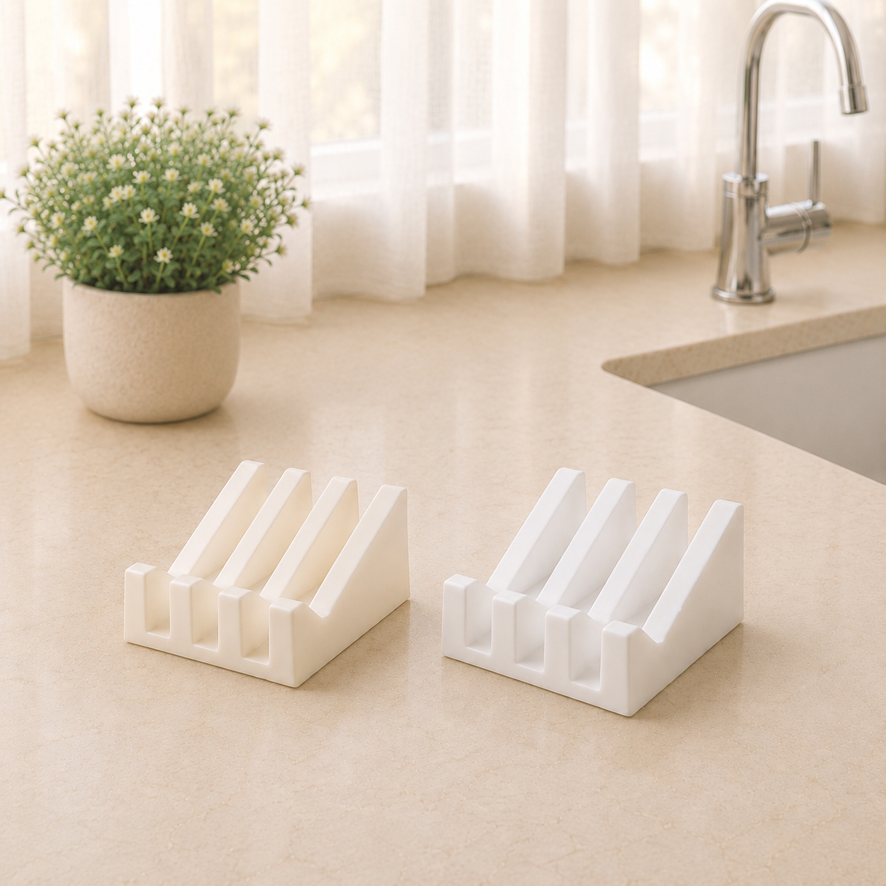 White and ivory ridged soap dishes displayed side by side on a beige bathroom countertop with soft morning light, sheer curtains, a faucet, and a potted floral arrangement.