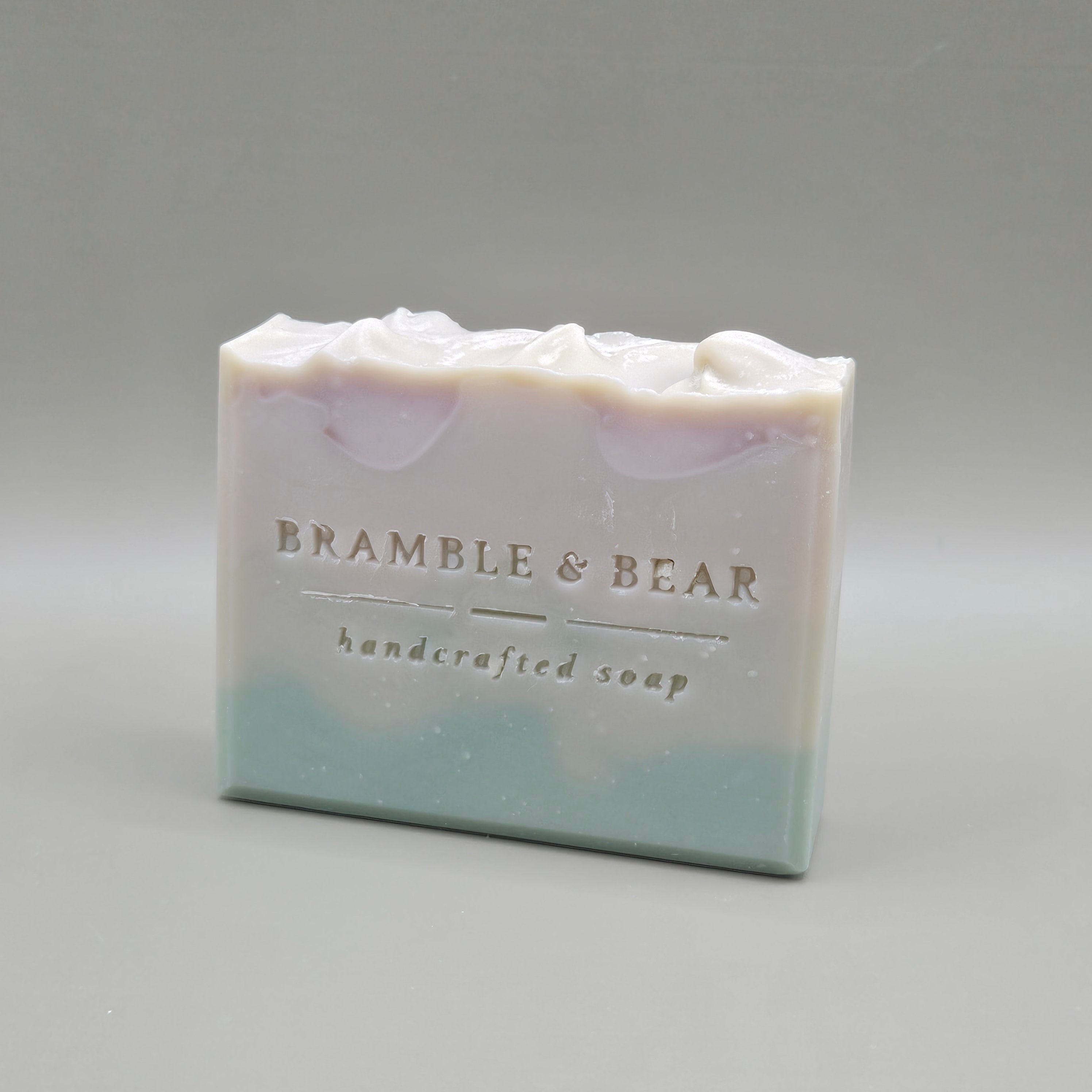 A bar of Juniper Amber Sky soap facing left against a plain gray background.
