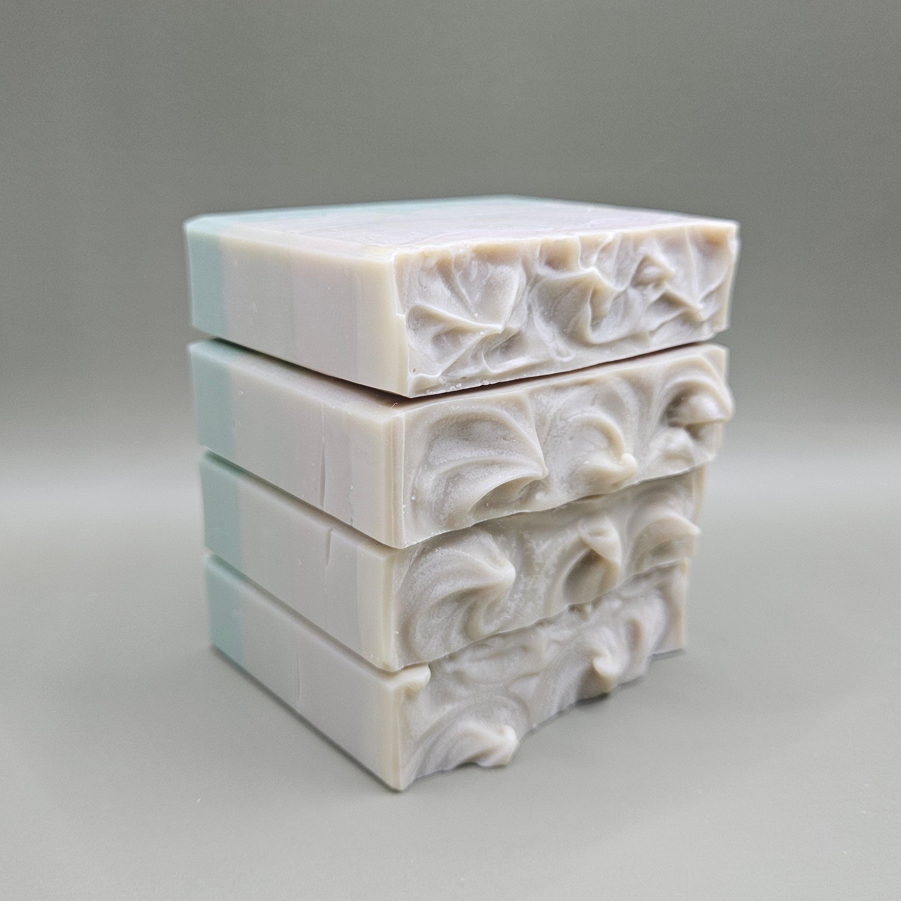 Three Juniper Amber Sky soap bars stacked vertically against a plain gray background