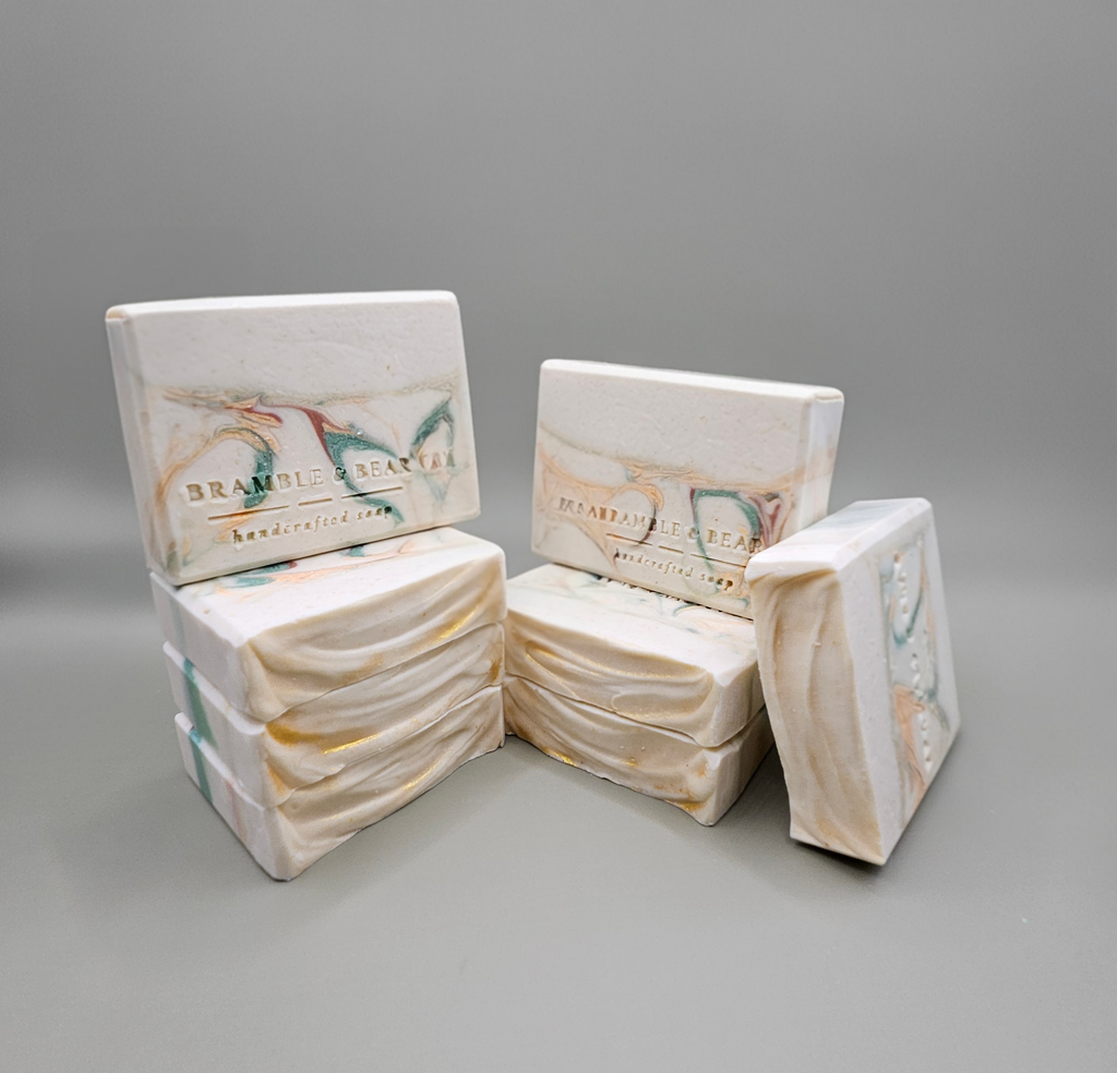 A few Juniper Amber Sky soap bars stacked up vertically against a plain gray background