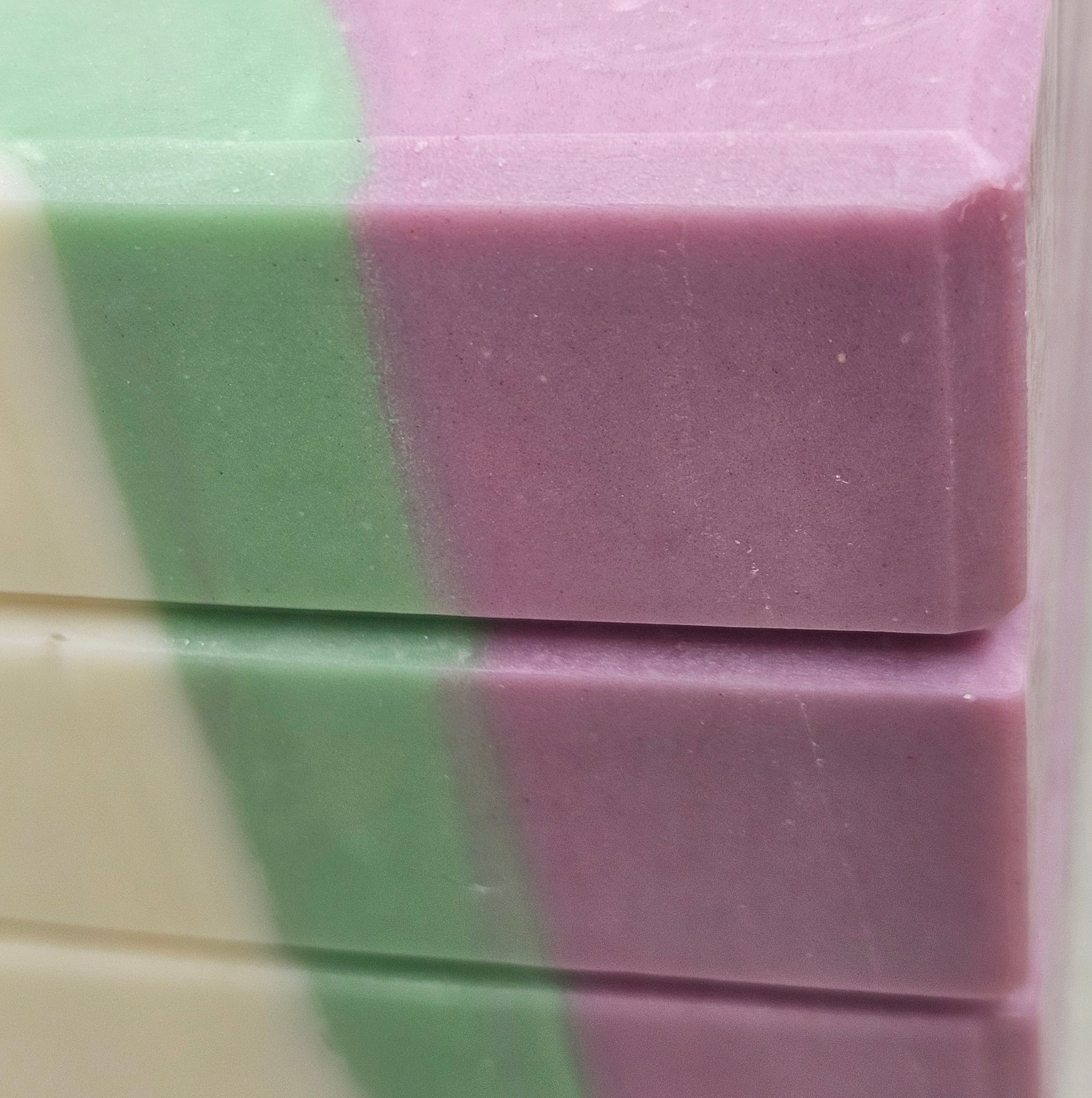 Close-up of Alpine Lavender Mint soap showing smooth lavender and mint green layers, soft ivory edges, and subtle handmade texture.