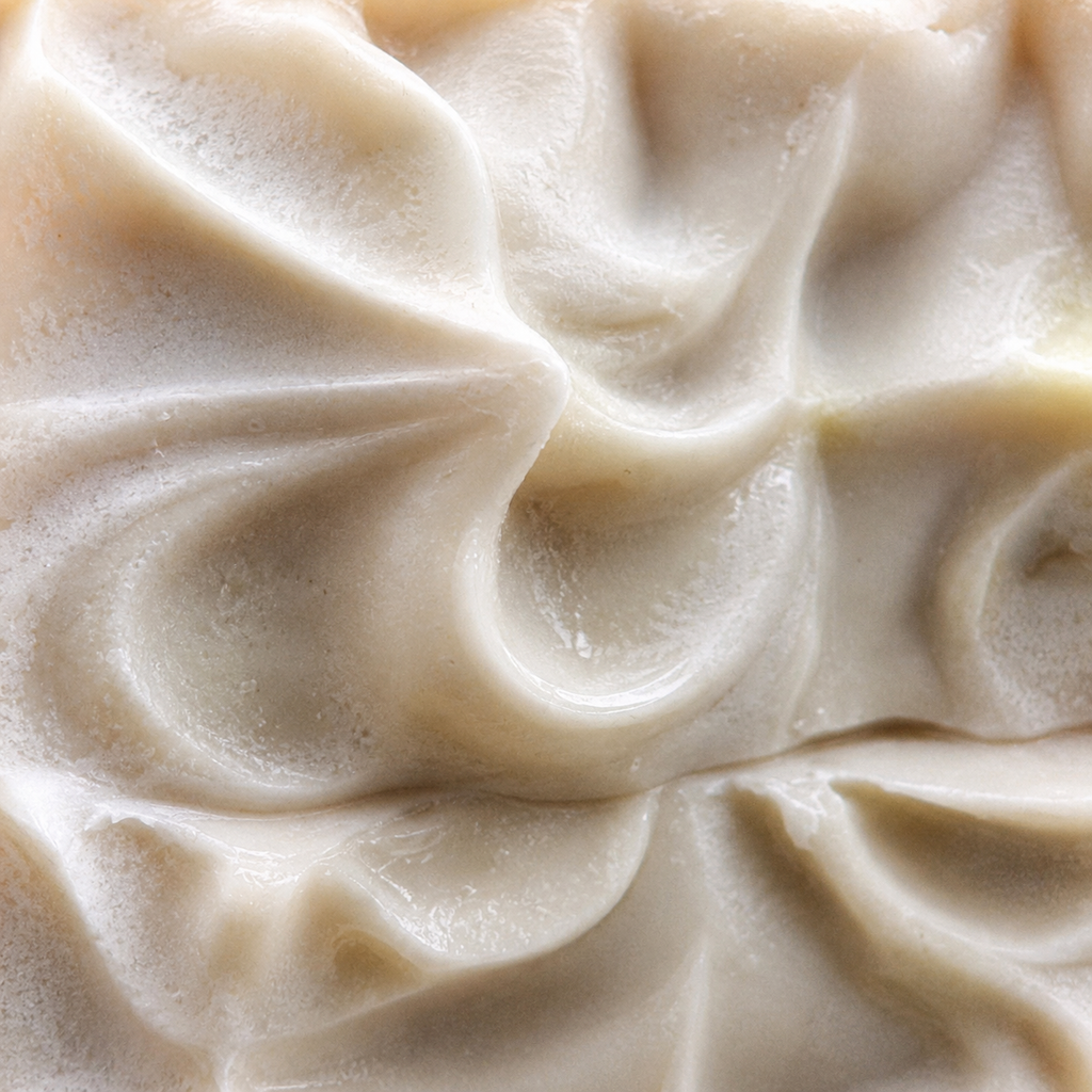 Close-up of Juniper Woodland Sunset handmade soap showing creamy whipped cold-process texture, soft ivory tones, subtle handmade surface details, and sculpted peaks.