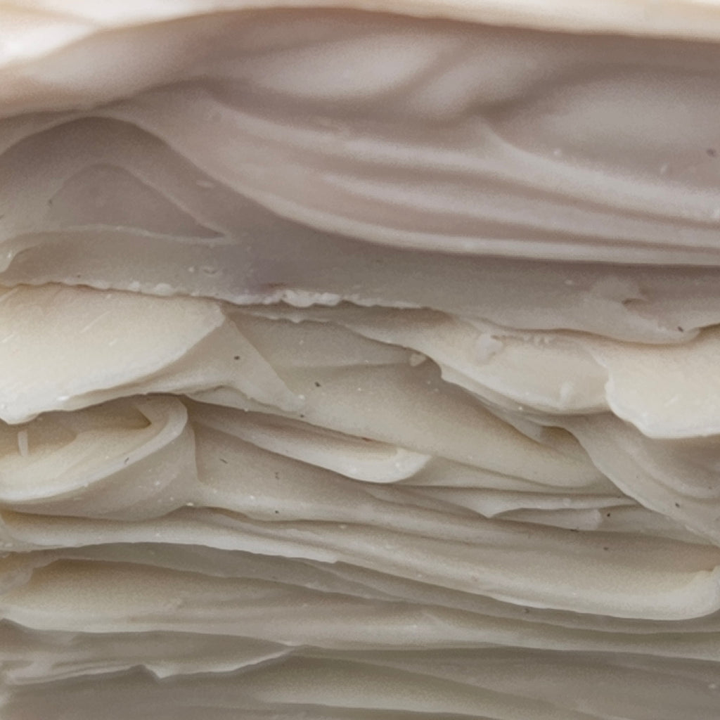 Close-up of the creamy white swirled top texture of Forest Berry Cake handmade soap.