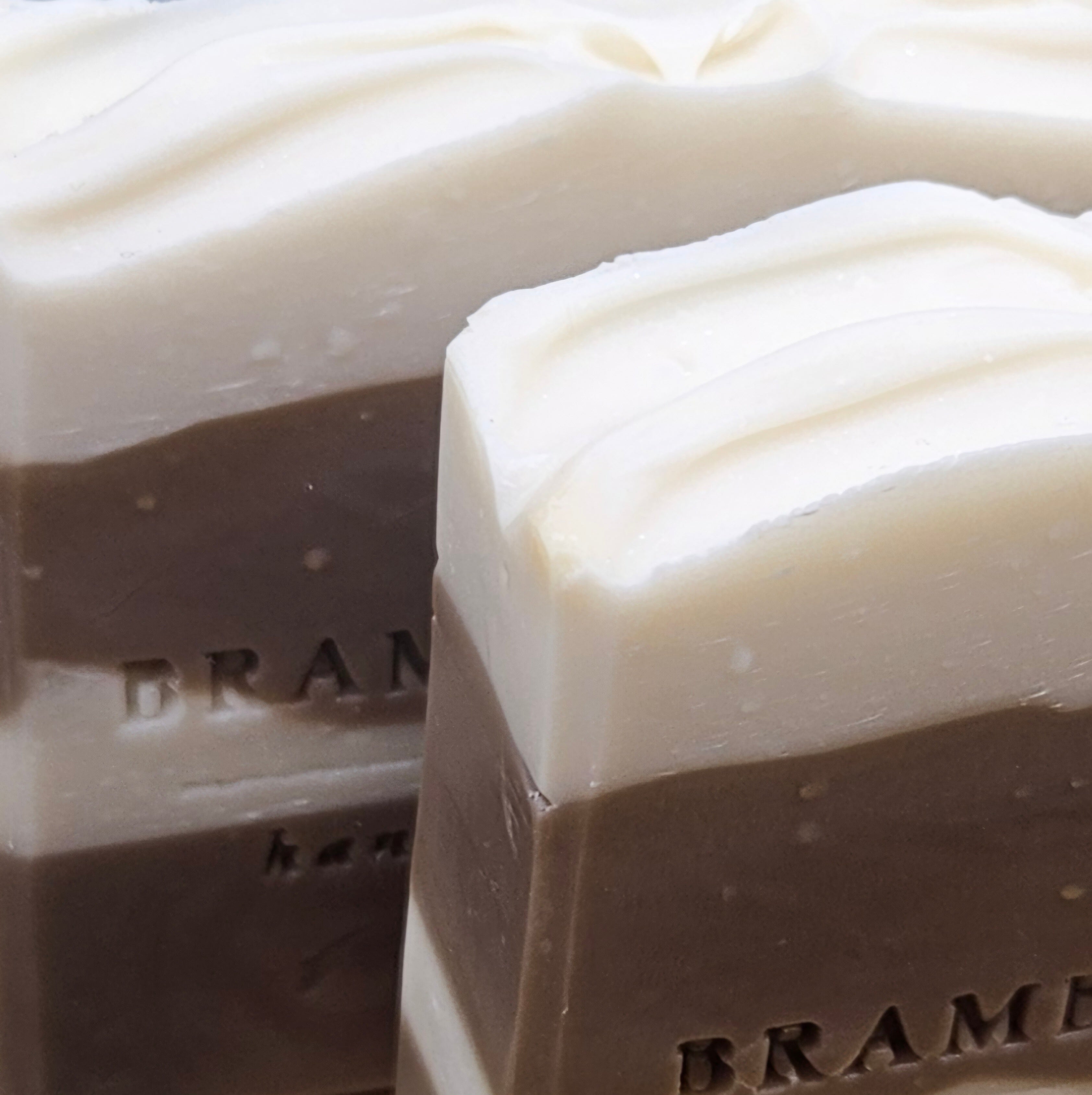 Close-up of creamy white Frosted Gingerbread Cream soap tops with softly hand-swirled, frosting-like texture.